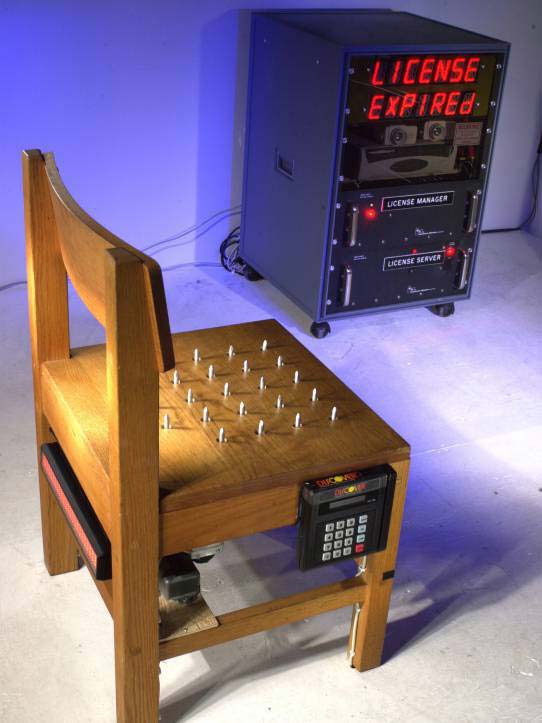 Wearable computing exhibit at San Francisco Art Institute 2001 Feb. 7th. This exhibit comprised a chair with spikes that retract for a certain time period when a credit card is inserted to purchase a 